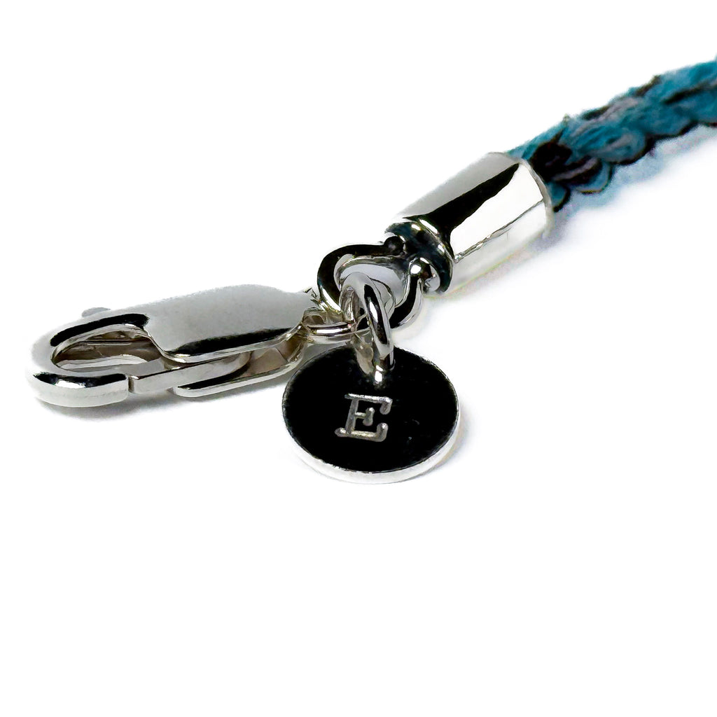 Dog keepsake bracelet with blue cord and silver clasp and letter charm on a white background